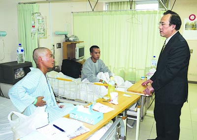 驻福冈总领事馆首席领事郭宝忠(右)昨慰问盐城籍获救船员纪长丰(左)和无锡籍的耿文磊。新华社发