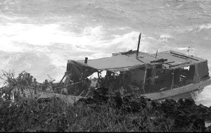 撞崖 偷渡船被巨大的海浪抛向崖壁。